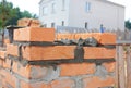 Bricklaying house brick wall. Close up on laying bricks with concrete