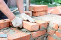 Bricklaying house wall, masonry. Bricklayer hands in masonry gloves bricklaying house wall