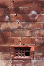 A bricks and mortar wall with broken air vent Royalty Free Stock Photo