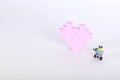 The bricks of the plastic constructor in the form of pink heart whith little robot. White background. Royalty Free Stock Photo