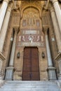 Bricks stone wall with arabesque decorated wooden door and marble engraved columns, al Refai Mosque