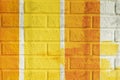 Bricks surface of wall, painted striped in bright orange and yellow colors. Graphic texture of colorful wall, for Royalty Free Stock Photo