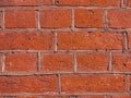 Brickwork made of red orange geometric horizontal bricks bonded with cement grout between square stones. Wall exterior. Royalty Free Stock Photo