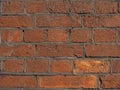 Brickwork made of red orange shine golden geometric horizontal bricks bonded with cement grout between square stones. Wall Royalty Free Stock Photo