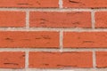 Brickwork rectangular red stones cracks with cement gray lines parallel row natural wall close-up grunge background Royalty Free Stock Photo