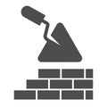 Brickwork and trowel solid icon. Spatula tool and building brick wall symbol, glyph style pictogram on white background