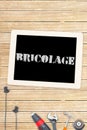 Bricolage against tools and tablet on wooden background Royalty Free Stock Photo