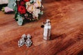 Bridal attributes such as elegant silver earrings with gem and perfume stand next to the wedding bouquet