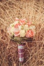 Bridal autumn bouquet with red and white roses over yellow autumn grass.