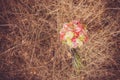 Bridal autumn bouquet with red and white roses over yellow autumn grass.