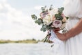 Bridal bouquet. Beautiful wedding pink and white flowers in hands of the bride. Close up outdoor shot against nature background. Royalty Free Stock Photo