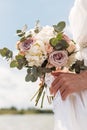 Bridal bouquet. Beautiful wedding pink and white flowers in hands of the bride. Close up outdoor shot against nature background. Royalty Free Stock Photo