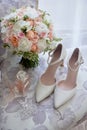 Bridal bouquet, bride shoes and earings on chair, copy space. Luxury wedding accessories and jewelry. Wedding concept. Royalty Free Stock Photo