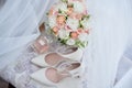 Bridal bouquet, bride shoes and earings on chair, copy space. Luxury wedding accessories and jewelry. Wedding concept. Royalty Free Stock Photo