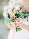 Bride in white dress holding wedding bouquet with tender flowers Royalty Free Stock Photo