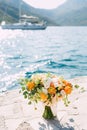 Bridal bouquet of cream roses, eucalyptus tree branches, yellow and orange buttercups, not blooming buds of white