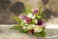 Bridal bouquet laying on stone block. Beautiful romantic white and magenta wedding flowers with copy space and blurred background Royalty Free Stock Photo
