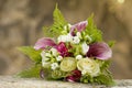 Bridal bouquet laying on stone block. Beautiful romantic white and magenta wedding flowers with copy space and blurred background Royalty Free Stock Photo