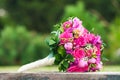 Bridal bouquet laying on wood block. Beautiful romantic white and magenta wedding flowers with copy space and blurred background. Royalty Free Stock Photo