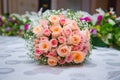 Bridal bouquet with orange and pink roses of different size with handle on white background. Romantic wedding bouquet with beautif Royalty Free Stock Photo