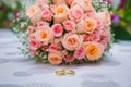 Bridal bouquet with orange and pink roses of different size with handle on white background. Wedding bouquet with beautiful flower Royalty Free Stock Photo