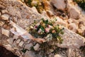 Bridal bouquet of pink roses, eucalyptus tree branches, lily and white ribbons on the stone wall Royalty Free Stock Photo