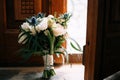 Bridal bouquet of pink and white roses, tulips, branches of eucalyptus tree, eryngium, scabiosa and white ribbons on the Royalty Free Stock Photo