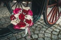 Bridal bouquet with red, pink and white roses and white callas on the step of a carriage Royalty Free Stock Photo