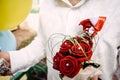 Bridal bouquet of red roses in the hands of groom