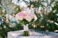 Bridal bouquet of rose and cream roses and calla lilies white stone railway near the blooming rose oleander bush