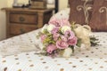 Bridal bouquet of roses with a hand fan on a bed