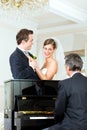 Bridal couple in front of a piano Royalty Free Stock Photo