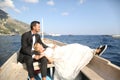 Bridal couple sitting in a wooden boat Royalty Free Stock Photo