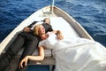 Bridal couple sitting in a wooden boat Royalty Free Stock Photo