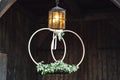 Bridal decoration hanging on vintage lamp. Bonded pair of big wedding rings with floral decoration. Wooden background