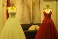 Bridal and evening dresses on mannequins at fashion store.