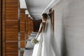 Bridal fashion model with perfect body in fashionable wedding dress posing with a bouquet of flowers in the interior Royalty Free Stock Photo