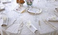 Bridal mise en place with white lace tablecloth and silver cutlery