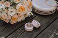 Bridal morning details composition. Top view of wedding rings, beautiful bouquet of pink flowers with ribbons, boutonniere and Royalty Free Stock Photo