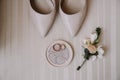 Bridal morning details composition. Top view of wedding rings, beautiful bouquet of pink flowers with ribbons, boutonniere and Royalty Free Stock Photo