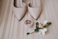 Bridal morning details composition. Top view of wedding rings, beautiful bouquet of pink flowers with ribbons, boutonniere and Royalty Free Stock Photo