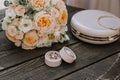 Bridal morning details composition. Top view of wedding rings, beautiful bouquet of pink flowers with ribbons, boutonniere and Royalty Free Stock Photo