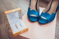 Bridal morning details composition: wedding rings and blue leather shoes. Royalty Free Stock Photo