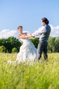 Bridal pair dancing on field celebrating