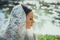 bridal portrait of beautiful blue eyes woman with lace veil outdoor