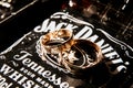 Bridal rings on a bottle of whiskey by Jack Daniels on a dark background