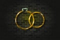 Bridal rings golden glowing neon sign or glass tube on a black brick wall. Realistic vector art