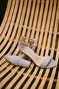 Bridal sandals close-up on a chair made of wooden rods. Royalty Free Stock Photo