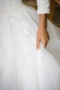 Bridal white dress close up crop hand holding pulling up