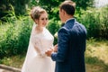 The bride adjusts her jacket to her fianc and smiles at him. Lovers spend time outside the city. Royalty Free Stock Photo